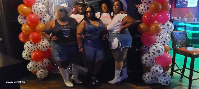 BBW Parties guests posing with balloon arch in the lounge